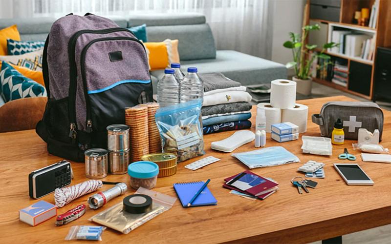 Backpack with emergency supplies on a living room table.