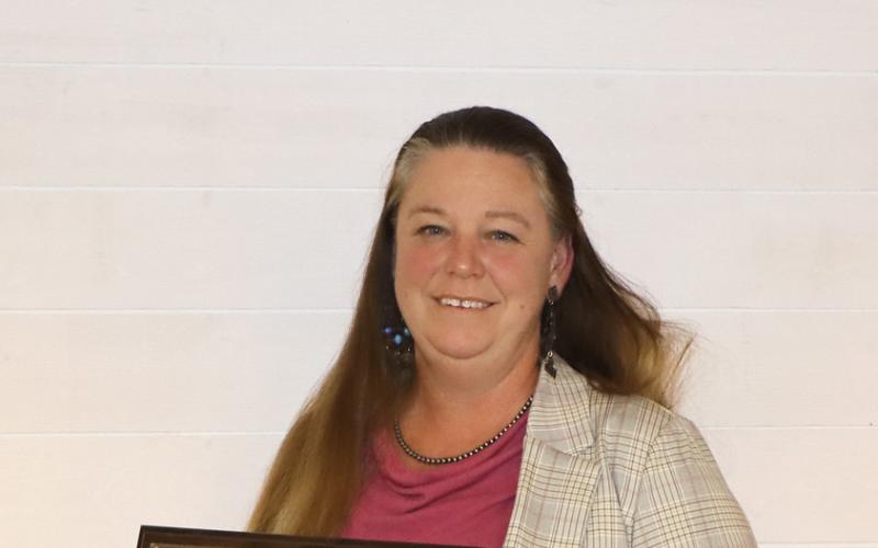 Heather Gessner smiles with her award plaque