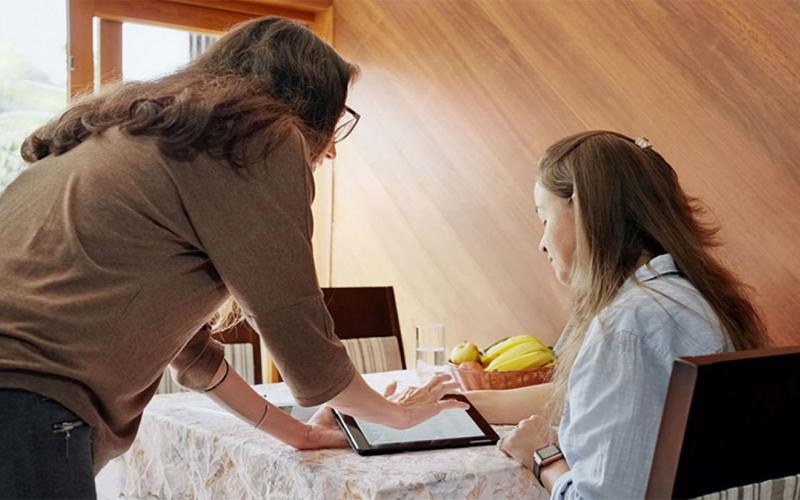 In-home dietician and client viewing information on a tablet computer.