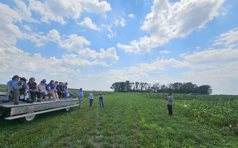 A group of people sitting on a trailer at a plot tour