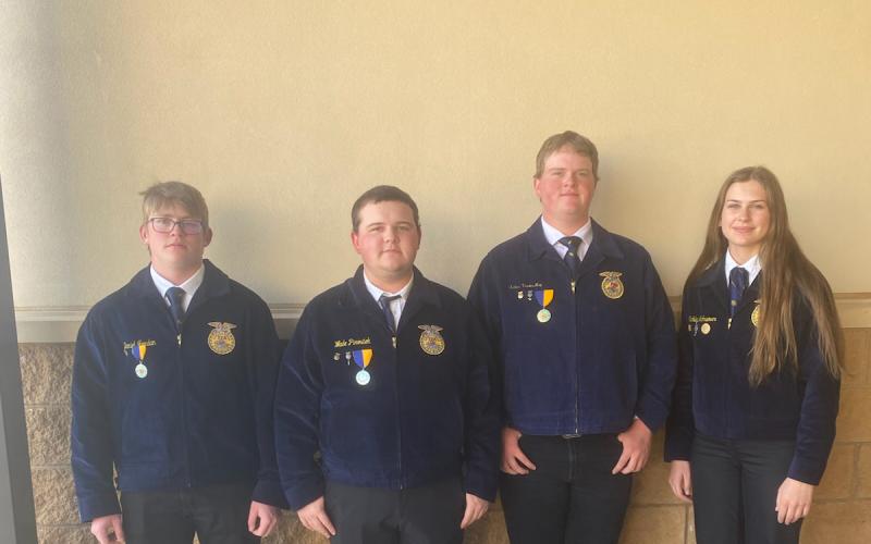 Four youth in matching blue FFA jackets pose for a team photo