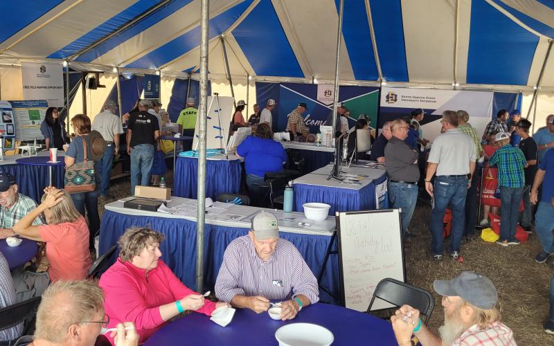 People eat ice cream under a large tent