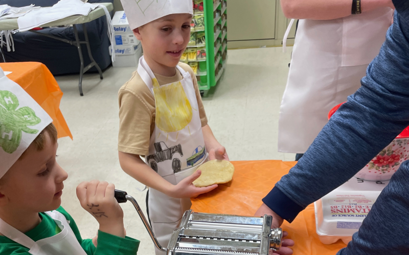 Two children making fresh pasta