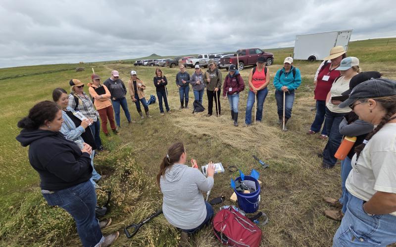 Women standing in a circle learning about rangeland plants