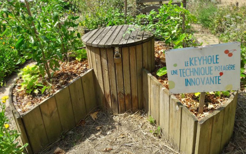 Wooden planks forming a raised circular garden bed with a notch in the side for access