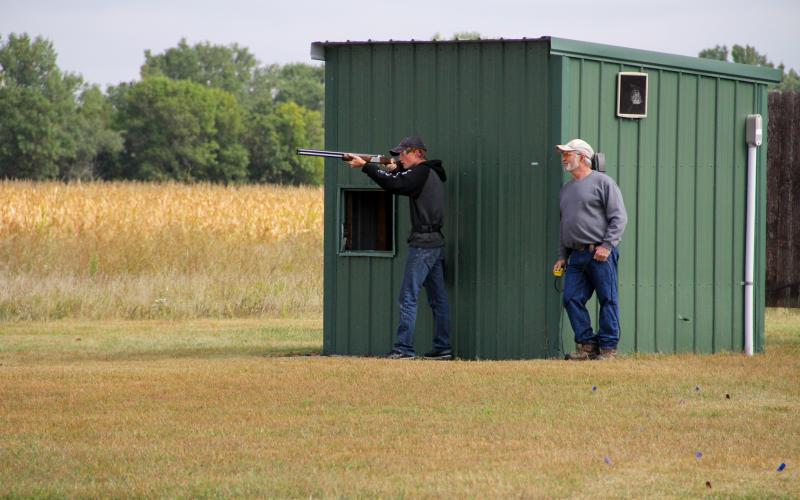 Shooting Sports coach helping youth shooting shotgun