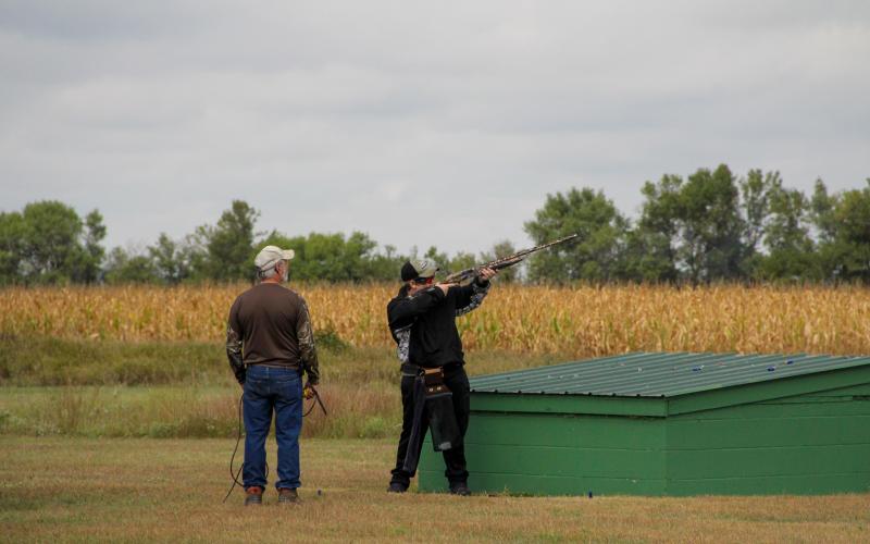 Shooting Sports coach helping youth shooting shotgun