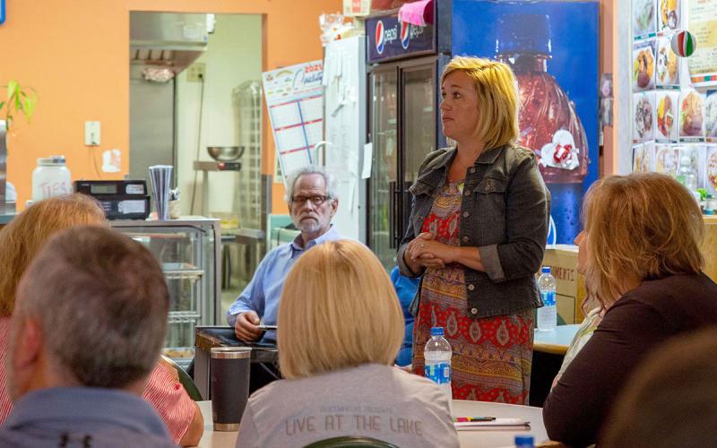 Woman standing up during a meeting in a local business.
