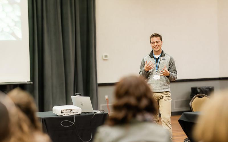 a yong man presenting to a group of people