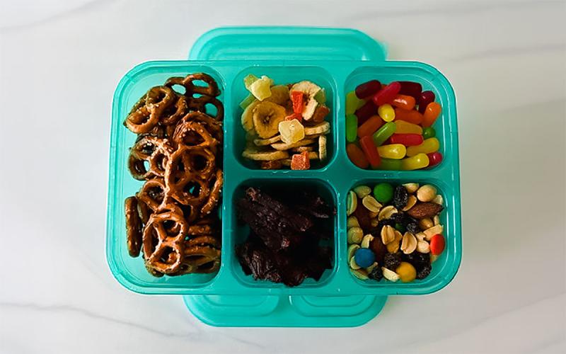 A variety of snacks sectioned off in a plastic container.